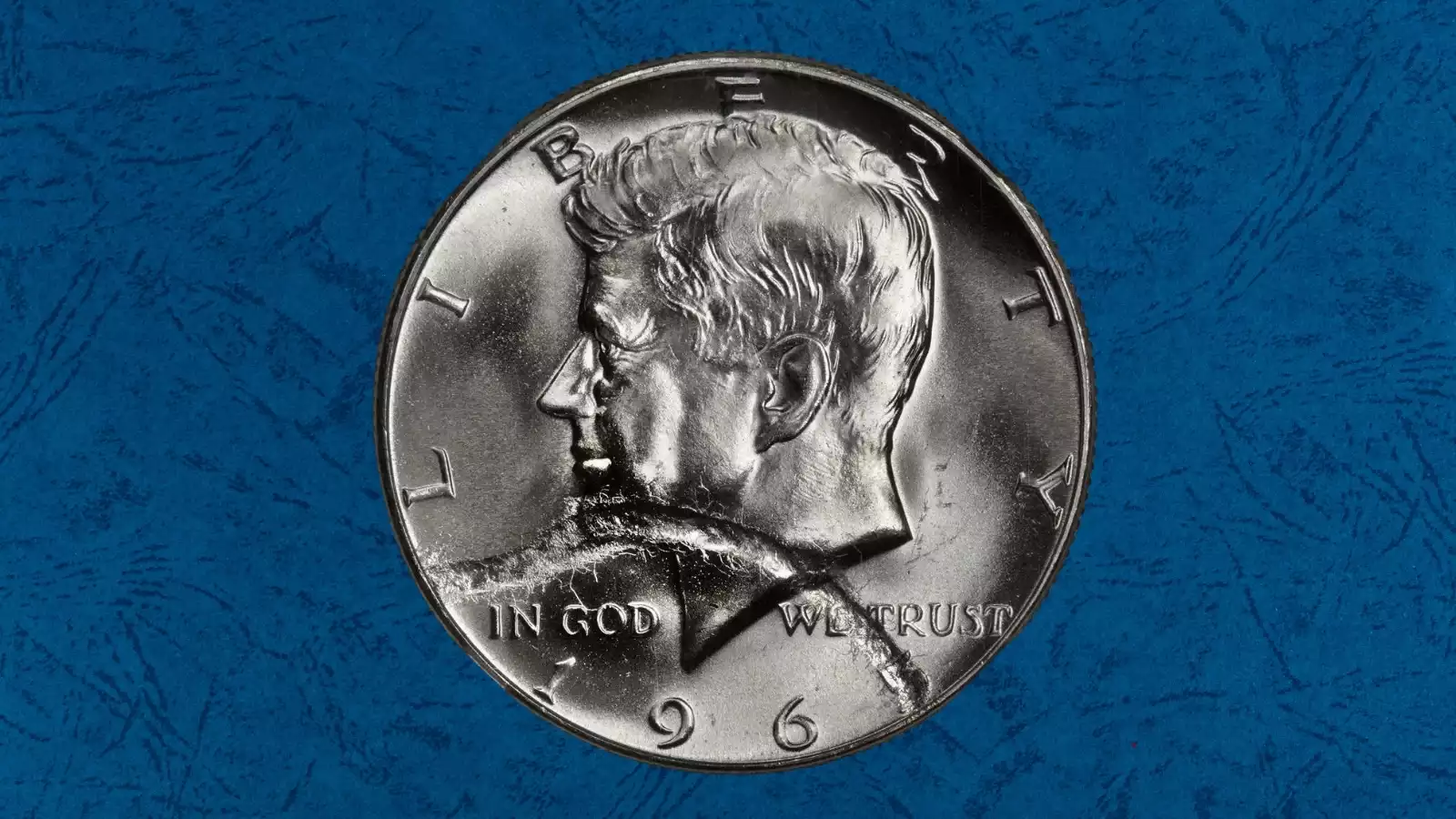 1965 Kennedy half dollar broad strike error showing wider diameter and missing reeded edge from collar-free striking